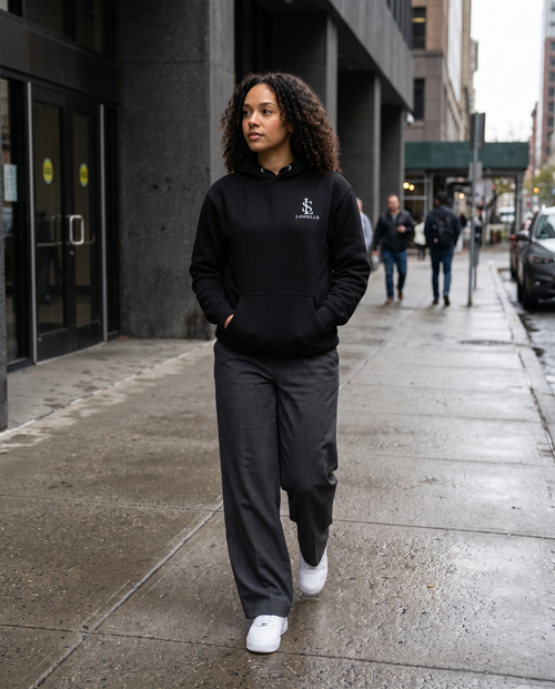 Build In Silence Hoodie in black worn by a female model on a city street
