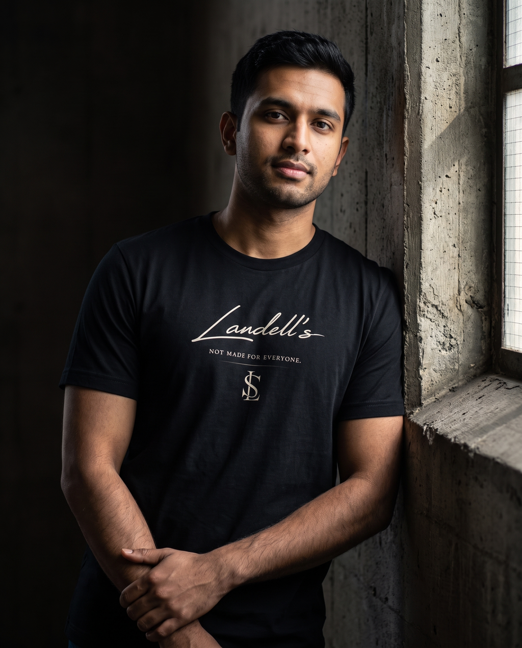 Model wearing the Landells Tee in black, relaxed side lean