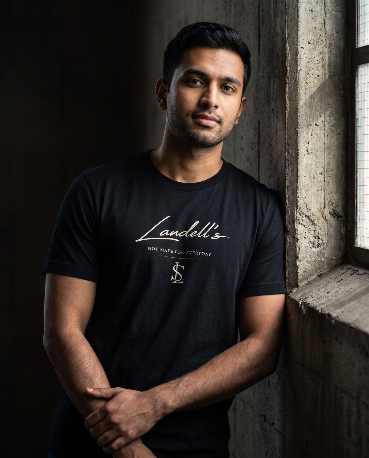 Model wearing the Landells Tee in black, relaxed side lean
