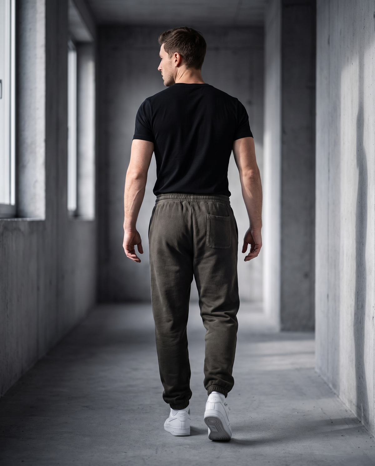 Landells Fleece Sweatpants in pepper, walking away in a corridor
