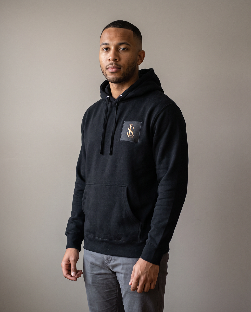 Heavyweight Hoodie in black worn by a man, studio view