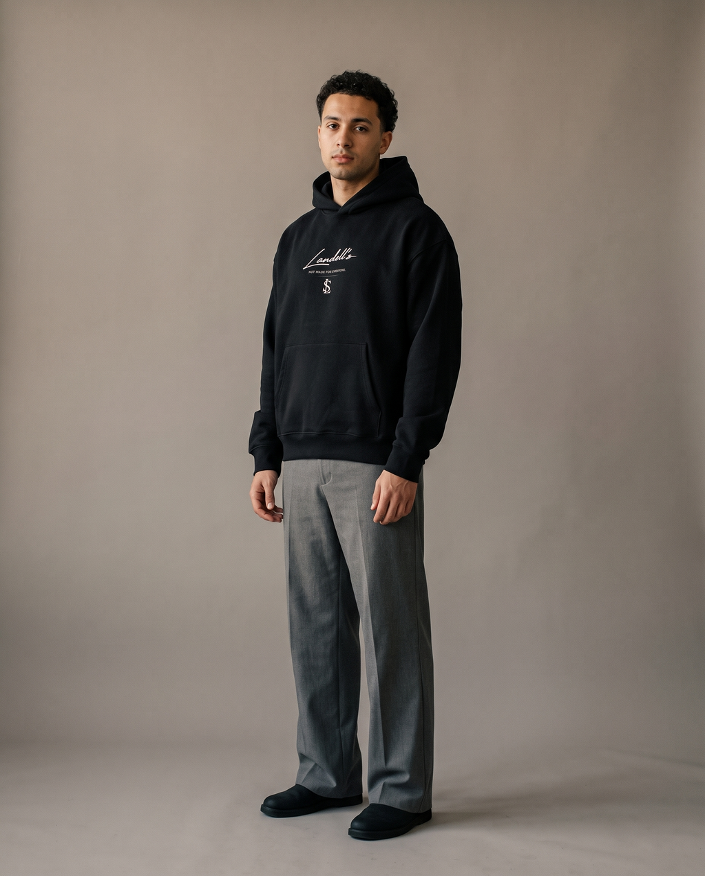 Oversized Hoodie in black worn by a man, studio view