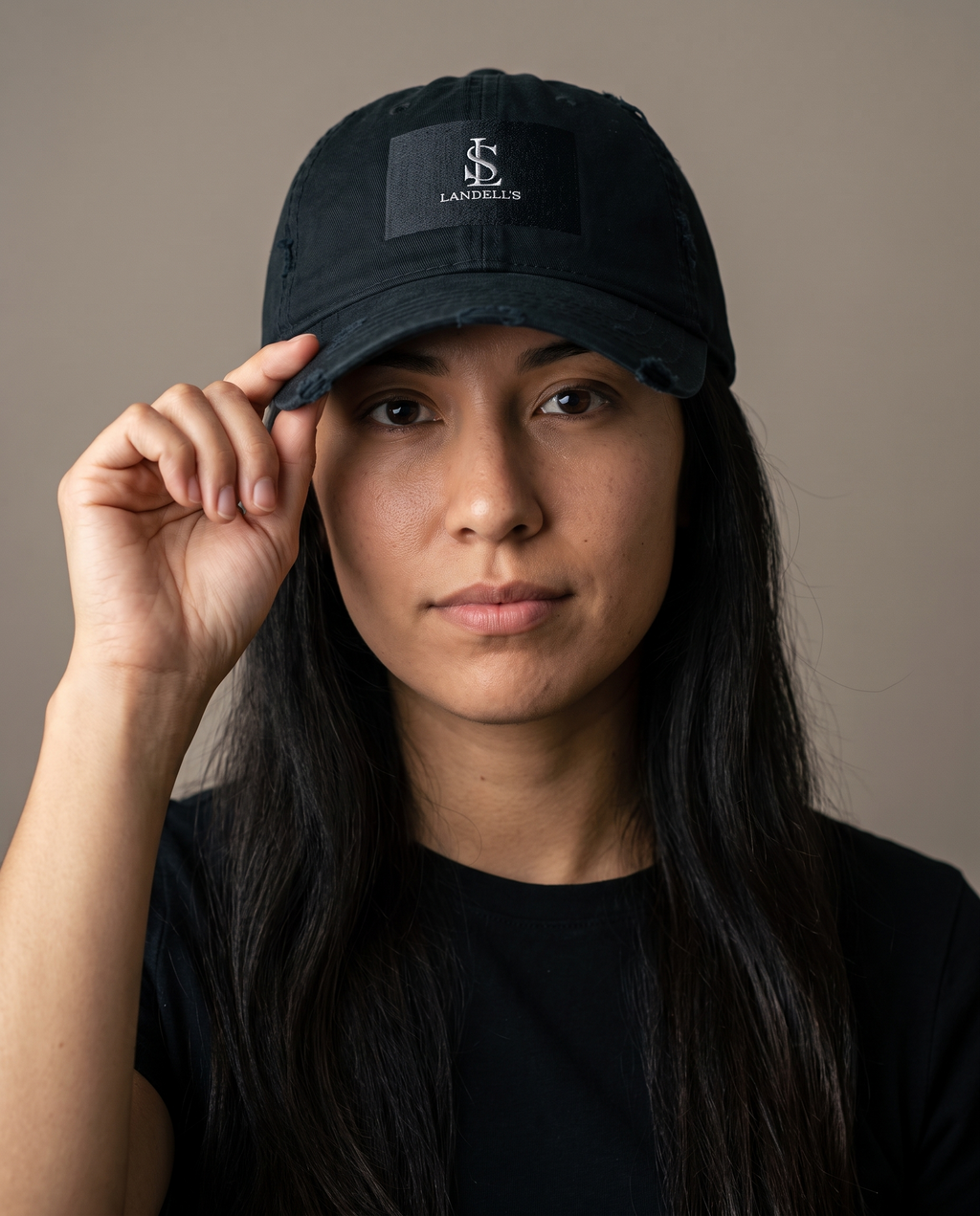 Worn Cap in black worn by a woman, studio portrait