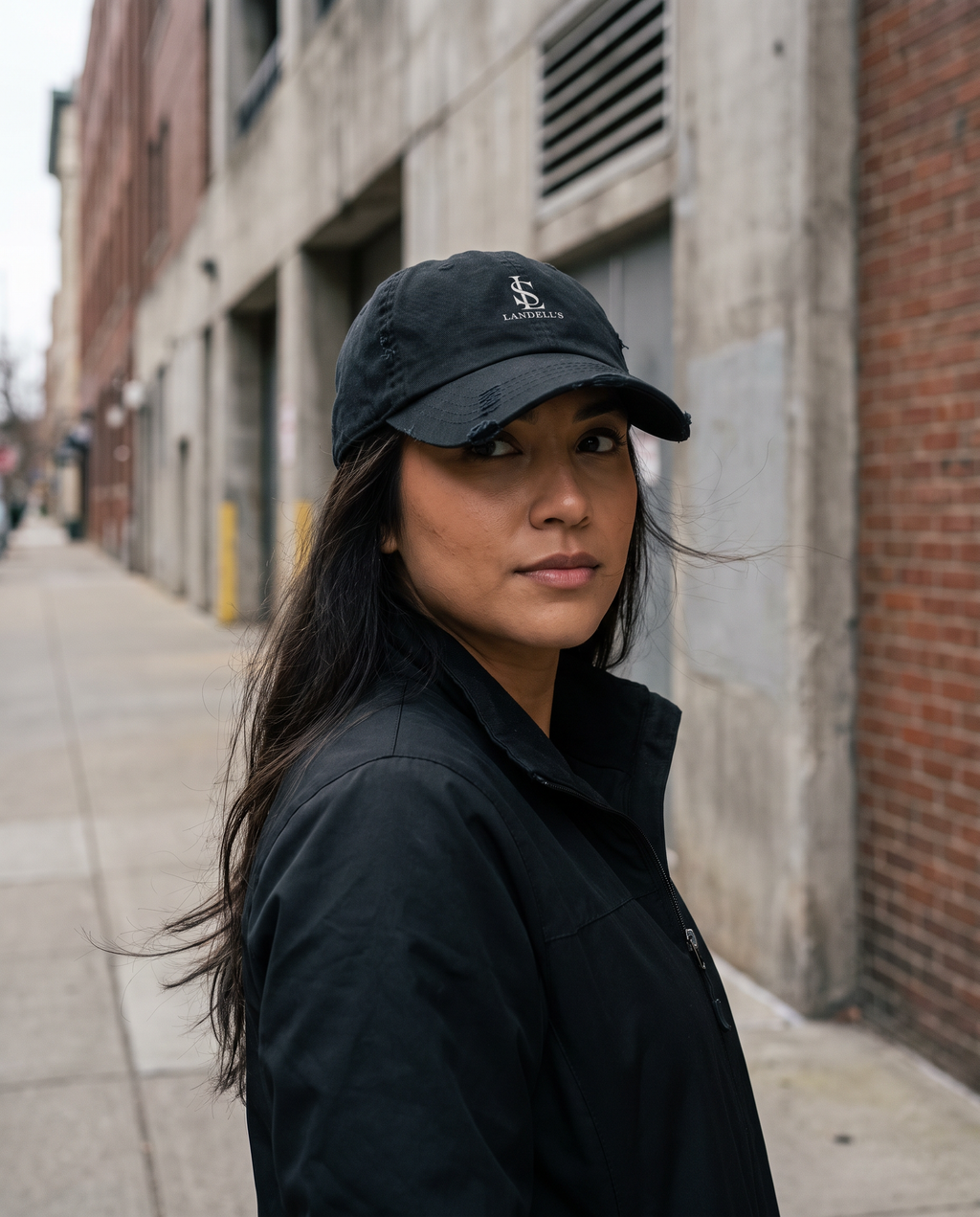Worn Cap in black worn on a city street