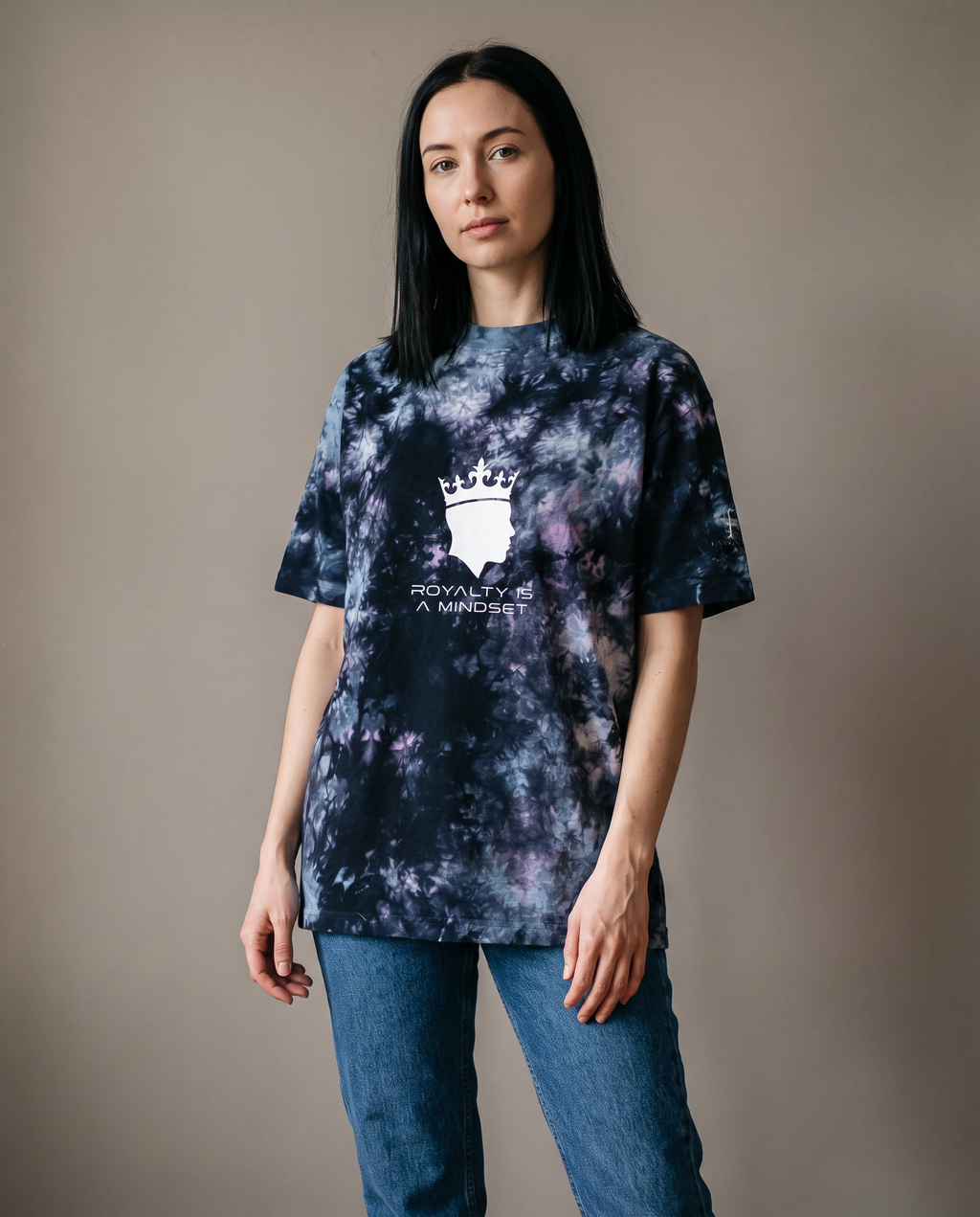 Woman wearing the Royalty Is a Mindset tie-dye tee with jeans, studio