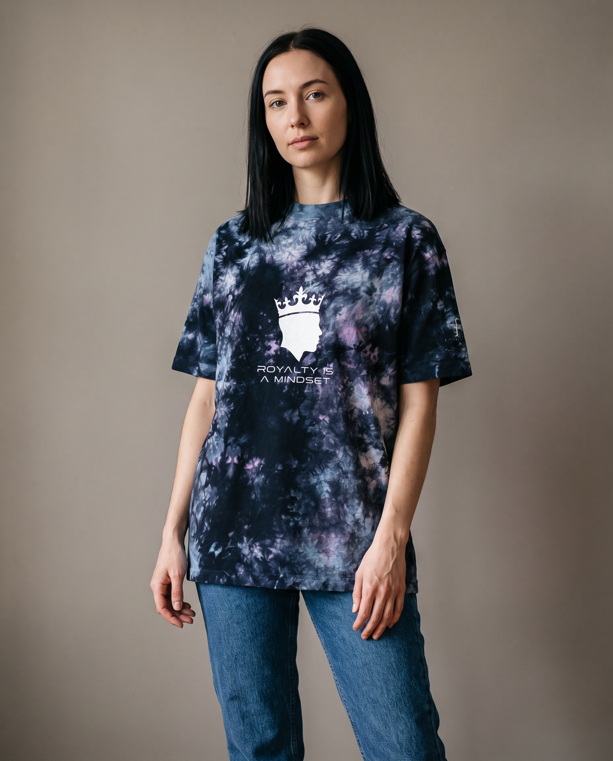 Woman wearing the Royalty Is a Mindset tie-dye tee with jeans, studio